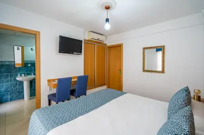 a bedroom with a bed and a desk and a sink at Hostal RR Feria by Beleret in Valencia