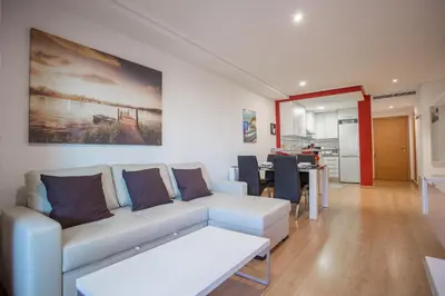 a living room with a white couch and a table at Apartment on the beach,pool,WiFi,garage,Valencia in Valencia