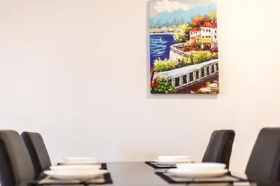 a painting hanging on a wall above a table with chairs at Apartment on the beach,pool,WiFi,garage,Valencia in Valencia