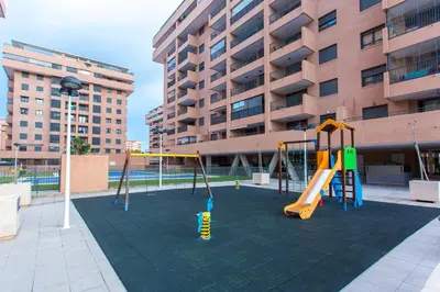 a playground in front of a large building at Apartment on the beach,pool,WiFi,garage,Valencia in Valencia
