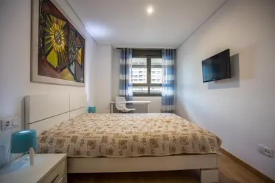 a bedroom with a bed and a tv on a wall at Apartment on the beach,pool,WiFi,garage,Valencia in Valencia
