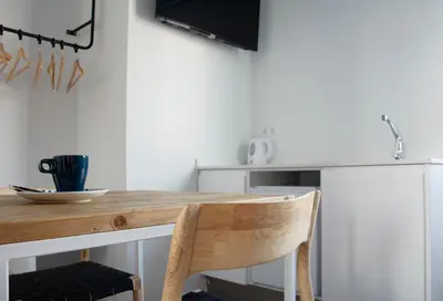 a kitchen with a wooden table and a chair at YOU & CO. Saler Beach Boutique in Valencia