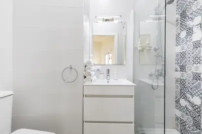 a white bathroom with a sink and a shower at Travel Habitat Ruzafa Apartment in Valencia