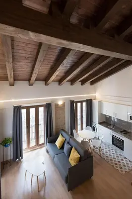 a living room with a blue couch and a kitchen at Old Town Flats Casa Burguerini in Valencia