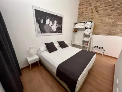 a bedroom with a large bed and a brick wall at Old Town Flats Casa Burguerini in Valencia