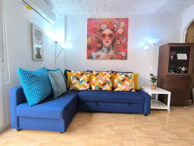 a blue couch in a living room with a painting at Valencia Central Apartment two bedrooms for Rent from more than 10 days in Valencia