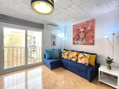 a living room with a blue couch and a painting at Valencia Central Apartment two bedrooms for Rent from more than 10 days in Valencia