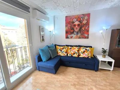 a living room with a blue couch and a painting at Valencia Central Apartment two bedrooms for Rent from more than 10 days in Valencia