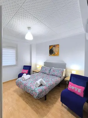 a bedroom with a bed and two blue chairs at Valencia Central Apartment two bedrooms for Rent from more than 10 days in Valencia