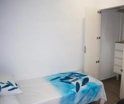 a bedroom with a bed with a blue blanket on it at MARIETA in Valencia