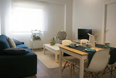 a living room with a blue couch and a table at MARIETA in Valencia