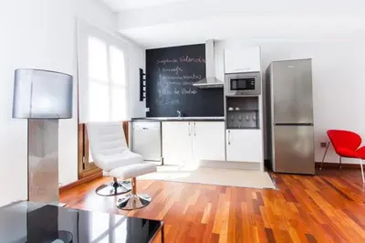 a kitchen with a refrigerator and a chair in it at Happy Apartments Valencia in Valencia