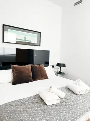 a bedroom with a large bed with two towels on it at Happy Apartments Valencia in Valencia