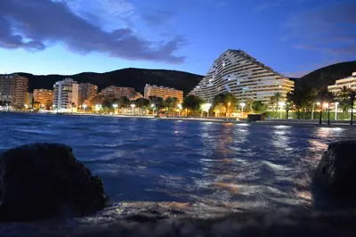 a view of a city from the water at night at Apartamentos Florazar II Ajhory in Cullera