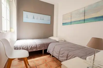 a small room with two beds and a chair at Colón Market Downtown in Valencia