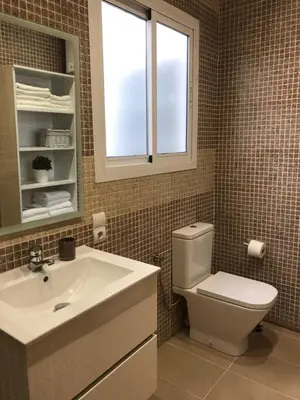 a bathroom with a toilet and a sink and a window at Colón Market Downtown in Valencia