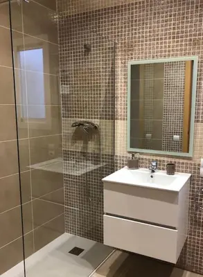 a bathroom with a sink and a shower with a mirror at Colón Market Downtown in Valencia