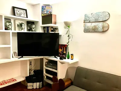 a living room with a flat screen tv on a shelf at Rio Turia Skatehouse in Valencia