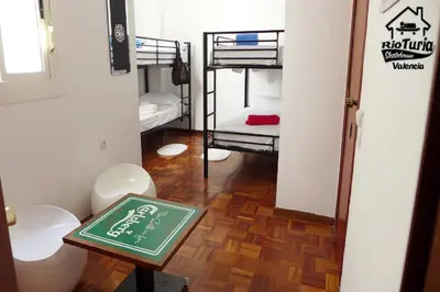 a room with bunk beds and a sign on a table at Rio Turia Skatehouse in Valencia