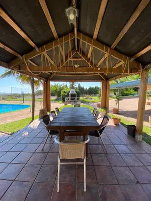 a wooden table and chairs under a wooden pergola at Villa Entrenaranjos in Picassent