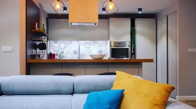 a living room with a blue couch and a kitchen at Hexagonal Design Apartment in Valencia