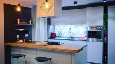 a kitchen with a counter and stools in it at Hexagonal Design Apartment in Valencia