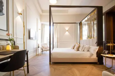 a bedroom with a canopy bed and a table at MYR Palacio Vallier in Valencia