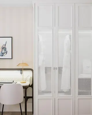 a bedroom with white cabinets and a table and a bed at MYR Palacio Vallier in Valencia