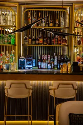 a bar with two chairs and bottles of alcohol at MYR Palacio Vallier in Valencia