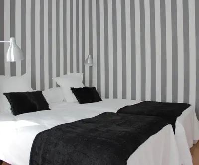 a bedroom with a bed with white sheets and black pillows at 7 Moons B&B in Valencia