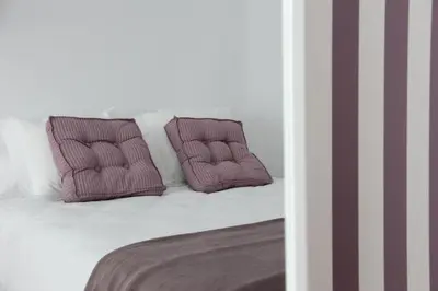a bed with two purple pillows on top of it at 7 Moons B&B in Valencia
