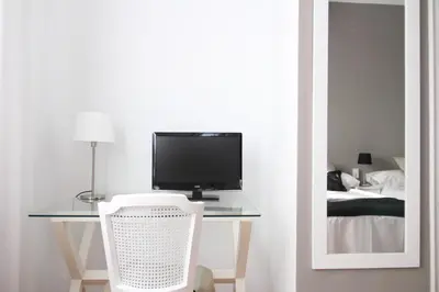 a room with a desk with a television and a chair at 7 Moons B&B in Valencia