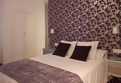 a bedroom with a large bed with a patterned wall at 7 Moons B&B in Valencia