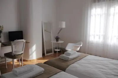 a bedroom with a bed and a desk with chairs at 7 Moons B&B in Valencia
