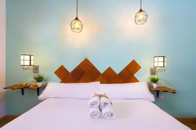 a bedroom with a white bed with a pair of slippers at Catedral Apartments in Valencia