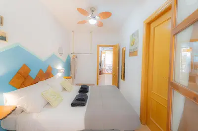 a bedroom with a white bed with a ceiling fan at Catedral Apartments in Valencia