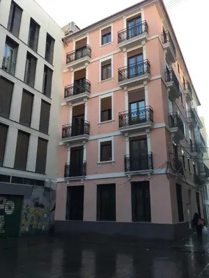 a pink building on a city street in the rain at Zerka Sendra in Valencia