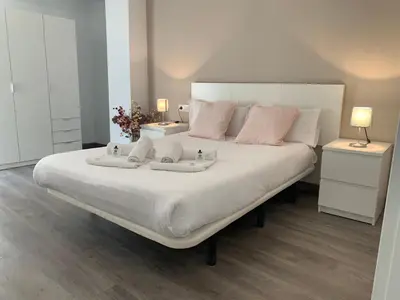 a bedroom with a large white bed with two night stands at Zerka Sendra in Valencia