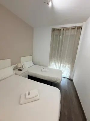 a white room with two beds and a window at Zerka Sendra in Valencia