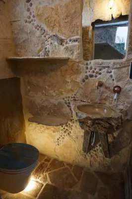 a stone bathroom with a sink and a toilet at CASA DEL ARTE casa rural in Chulilla