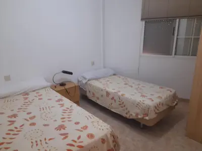 a room with two beds and a window at Apartamentos Chelo in Navajas