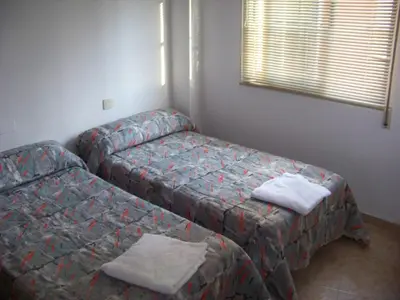 a bedroom with two beds and a window at Apartamentos Chelo in Navajas