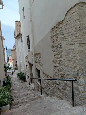 an alley with a stone wall and a building at Casa Centro Jérica in Jérica