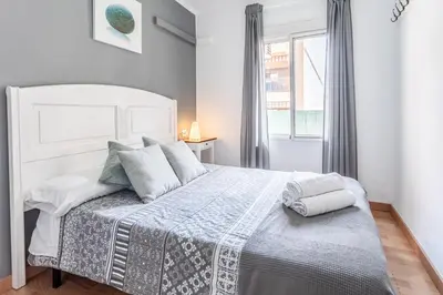 a bedroom with a large white bed with pillows at Casa los Buhos in Valencia