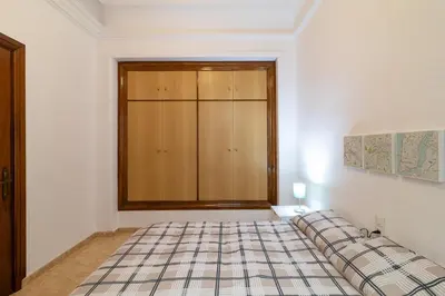 a bedroom with a bed and a cabinet in it at La Casa de los Espejos in Valencia