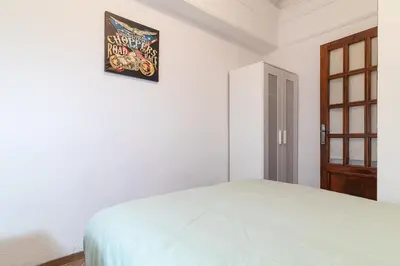 a bedroom with a bed and a picture on the wall at La Casa de los Espejos in Valencia