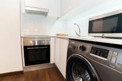 a kitchen with a washing machine and a microwave at Precioso Apartamento Cerca de Plaza España in Valencia