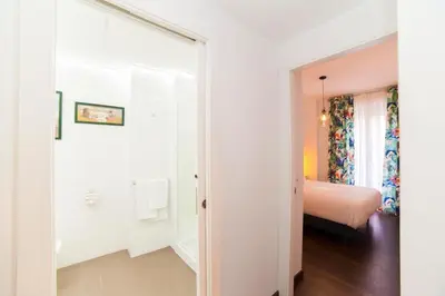 a white room with a bed and a door to a bedroom at Precioso Apartamento Cerca de Plaza España in Valencia
