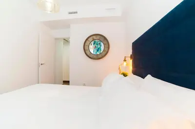 a bedroom with a large bed and a clock on the wall at Precioso Apartamento Cerca de Plaza España in Valencia