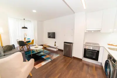 a kitchen and living room with a couch and a table at Precioso Apartamento Cerca de Plaza España in Valencia